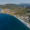 Spiaggia lunga e mare profondo vicino a colline verdi.